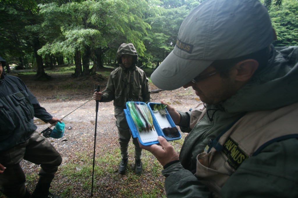 Un guía de pesca muestra las moscas al cliente. Foto: bancodepeces.es